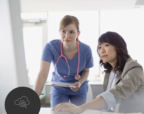 Woman working on computer with doctor