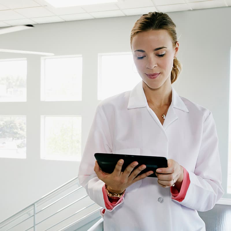 Doctor using digital tablet near railing,