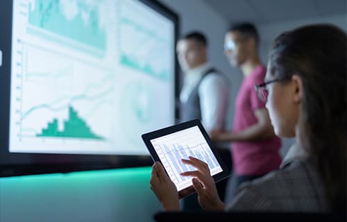 Businesswoman viewing graphs on digital tablet in business meeting