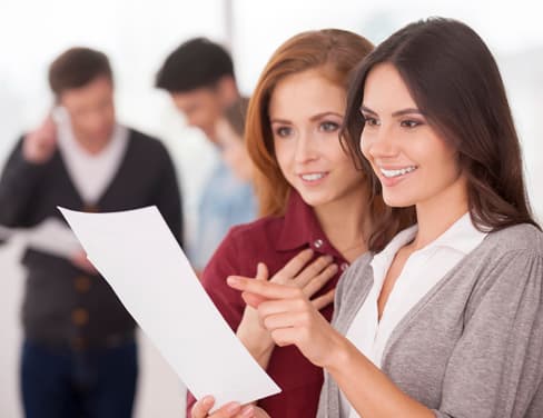 Ricoh two professional women reviewing printed document